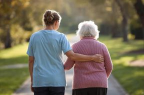 crea una immagine di badante che accompagna una anziana, entrambe di spalle (1)